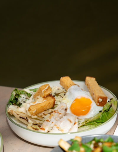 CAESAR SALAD 25 charred romaine heart, brioche croutons, crispy bacon, shaved pecorino, anchovy caesar dressing, fried egg